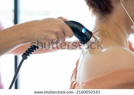 Physiotherapist treatment of back pain and nerves. Method of treatment with ultrasound machine and gel therapy health and medicine concept. Physiotherapy technique. office syndrome therapy. Royalty-Free Stock Photo #2160050143