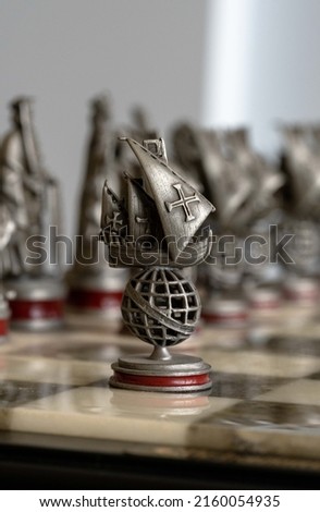 a lead portuguese caravel, decorative chess piece, a chess board, portugal army