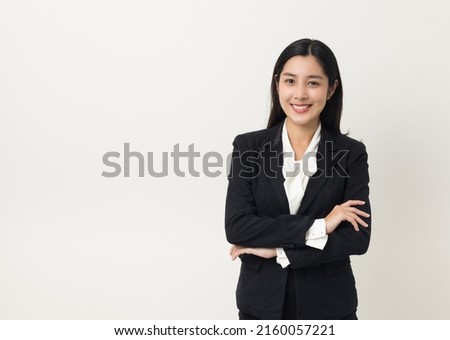 Young asian business woman smiling to camera standing pose on isolated white background. Female around 25 in suit portrait shot in studio. Royalty-Free Stock Photo #2160057221