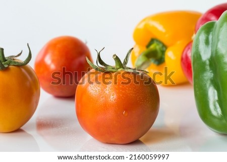 Close-up shot, spot focus Condensed yellow-orange tomatoes and other vegetables on a white background