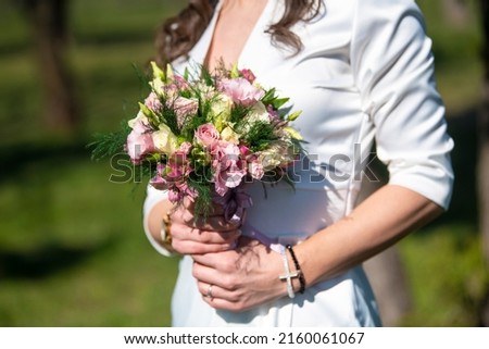 Beautiful Bride holds a wedding bouquet in hands. Wedding dress, wedding details.