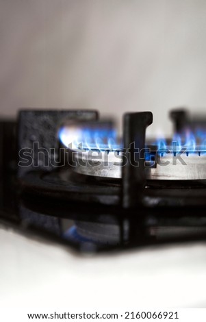 The stove is lit, and the gas is burning, utilities