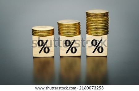 Percentage sign on wooden cubes with coins on top. on a dark table background. Financial.                    