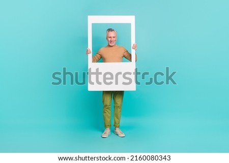 Full body photo of funny cheerful man hold paper window wear sweater isolated on teal color background
