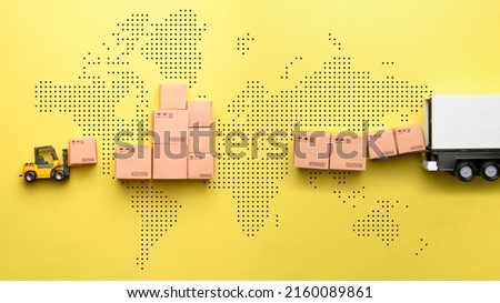The concept of logistics and delivery of goods. A loader loads goods into a truck against the backdrop of a world map Royalty-Free Stock Photo #2160089861