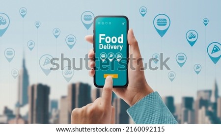 Woman ordering food delivery from restaurants online, city skyline and icons in the background Royalty-Free Stock Photo #2160092115