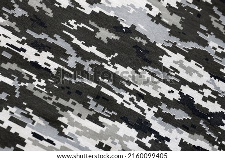 Fabric with texture of Ukrainian military pixeled camouflage. Cloth with camo pattern in grey, brown and green pixel shapes. Official uniform of Ukrainian soldiers close up