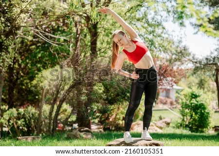 Young sporty woman warming up outdoors un the park