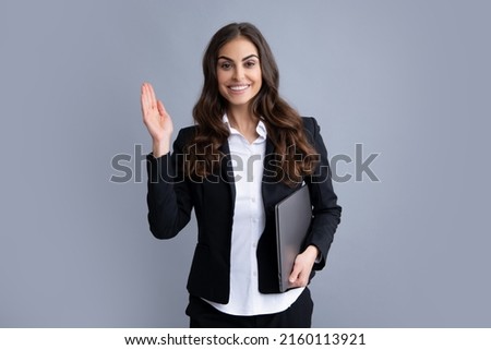 Cheerful business woman standing over grey wall with laptop computer. Portrait of pretty, charming, stylish, clever woman with laptop isolated on grey background.