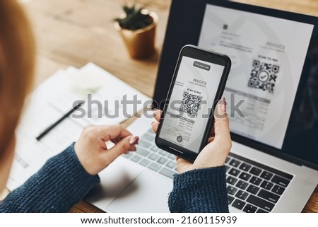 Woman scanning QR code from invoice to make payment using fast secure payment system and smartphone code reader. Business woman paying bills using express payment technology. Female using mobile phone Royalty-Free Stock Photo #2160115939