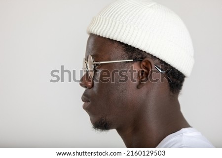 Portrait of an african american man in a white hat and eyeglasses.