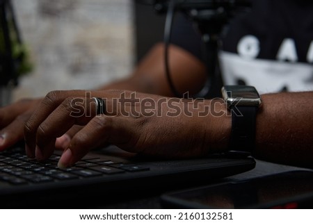 Close up of the hands of a popular African-American blogger in a podcast studio. Black radio DJ records a popular program for listeners in the studio