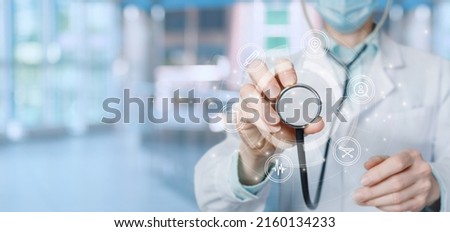 Doctor listen to a virtual computer screen with an interface of medical icons.
