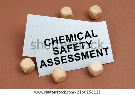 The concept of industrial safety. On a brown surface, wooden cubes and a business card with the inscription - Chemical Safety Assessment