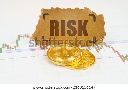 Business and technology concept. On the chart with quotes, there are bitcoins and there is a sign with the inscription - Risk