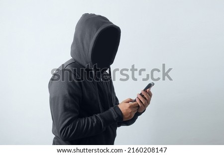 mysterious man wearing hoodie and holding phone Royalty-Free Stock Photo #2160208147