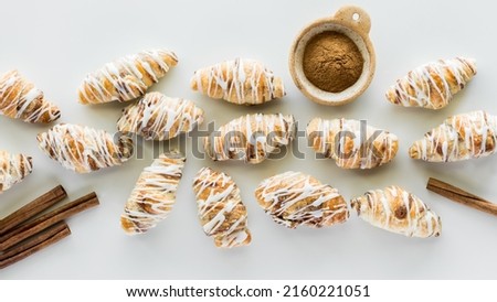 A horizontal row of mini cinnamon croissants drizzled with icing. 