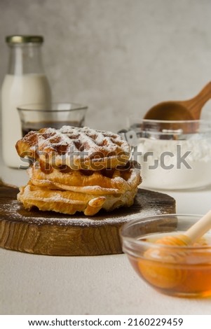 Warm of waffle for breakfast with honey, cup of coffee and milk on white table texture background