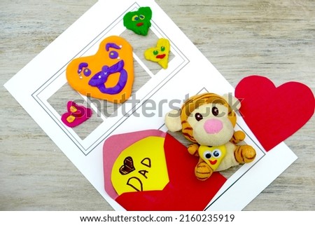 Preparing for Fathers day, Birthday or Valentines day . Child making funny crafts, greeting card from paper and clay, plasticine.  Arts  crafts concept.