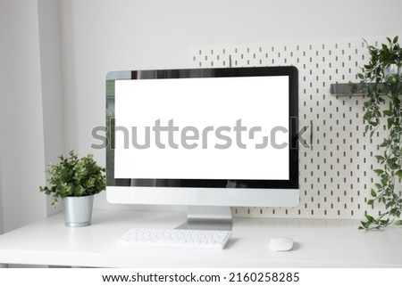 Close up view of workplace with computer, camera on white table.
