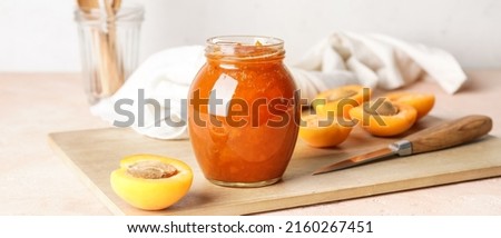 Jar of tasty apricot jam on table Royalty-Free Stock Photo #2160267451