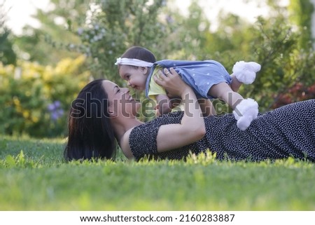 Young mother enjoying a idyllic summer day outdoor with her baby girl. Family portrait in the park.