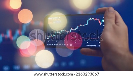 Trader investor broker holding finger using cell phone app executing financial stock trade market trading order to buy or sell Royalty-Free Stock Photo #2160293867