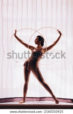 silhouette of Beauty woman dancing with hula hoops. Hula-hoop Royalty-Free Stock Photo #2160310425