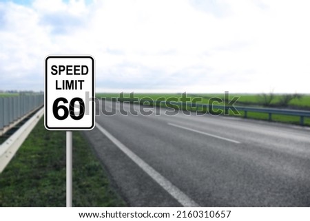 Traffic sign SPEED LIMIT 60 near empty asphalt road