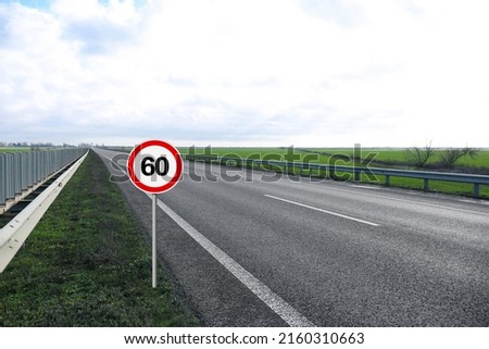 Traffic sign MAXIMUM SPEED 60 near empty asphalt road