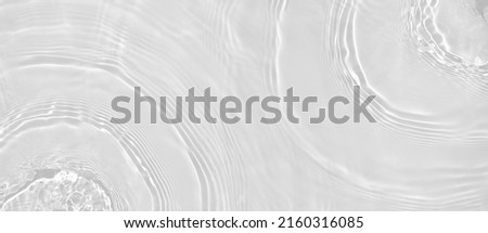 Abstract summer banner background Transparent beige clear water surface texture with ripples and splashes. Water waves in sunlight, copy space, top view. Cosmetics moisturizer micellar toner emulsion Royalty-Free Stock Photo #2160316085