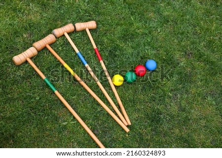 Set of croquet equipment on green grass, above view Royalty-Free Stock Photo #2160324893