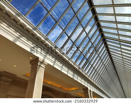 Skylight or glass sunroof ceiling of a building. Window in commercial office or industrial building. Modern design architecture, or energy conservation model using nature sunlight concept. Royalty-Free Stock Photo #2160332929