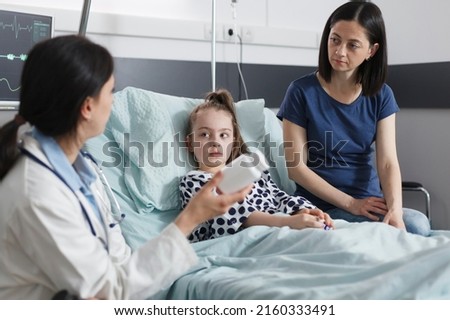 Healthcare facility clinic pediatric expert recommending ill patient girl right medicine for disease remission. Hospital pediatrist specialist talking with attentive mother about illness treatment. Royalty-Free Stock Photo #2160333491
