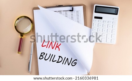 Clipboard with chart and text LINK BUILDING with magnifier ,calculator on a beige background