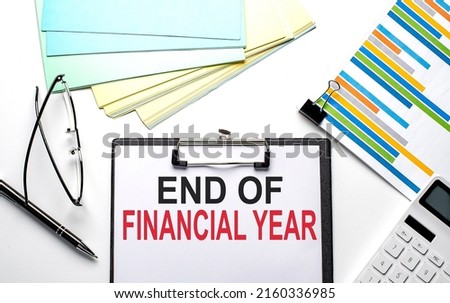 END OF FINANCIAL YEAR text on a paper sheet with chart,color paper and calculator