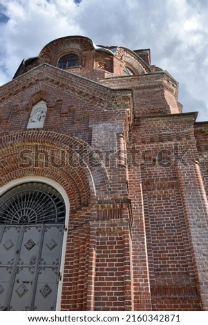  beautiful red brick Orthodox church. Blue sky with white clouds.