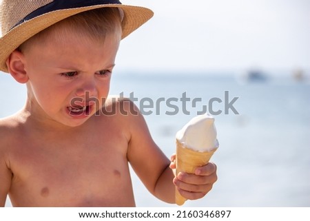 the child cries and eats ice cream on the beach. selective focus