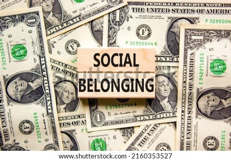 Social belonging symbol. Wooden blocks with concept words Social belonging on beautiful background from dollar bills. Business political social belonging concept. Copy space.