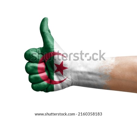 Hand making thumb up painted with flag of algeria