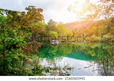 Waterfalls reflected in the lake. The magnificent landscape of the waterfall and lake. Majestic view of the Plitvice Lakes National Park. Soft focus