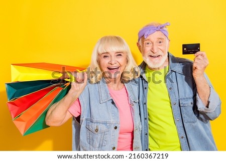 Photo of funky excited girlfriend boyfriend dressed denim outfit rising bargains bank card isolated yellow color background