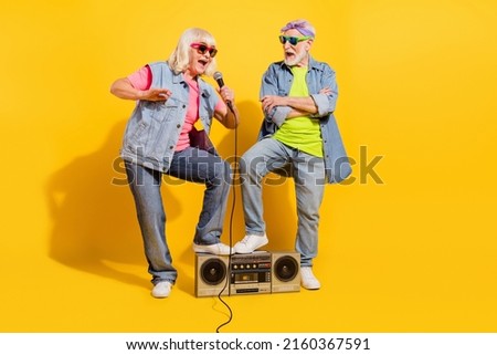 Photo of pretty cute husband wife wear jeans shirts singing boombox hands crossed isolated yellow color background