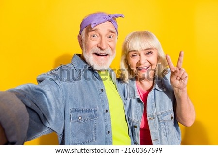 Photo of friendly boyfriend girlfriend pensioner dressed denim outfit recording video v-sign isolated yellow color background