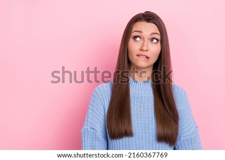 Photo of unsure young brown hairdo lady look promo wear blue sweater isolated on pink color background