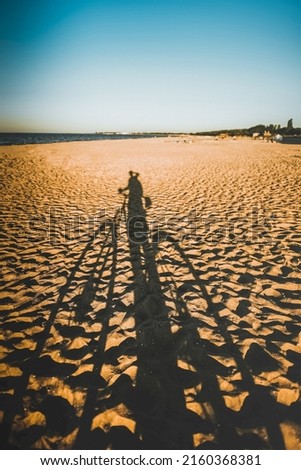 Summertime adventures during mountain bike riding on the sand beach. Concept photo of bike riding on the seaside. Long shadow on a sand beach