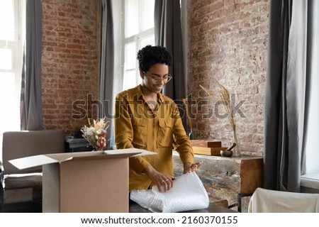 African woman pack parcel box for sending friend abroad, small business online webstore owner individual entrepreneur sell goods prepare package for client. Fast and trusted delivery services concept Royalty-Free Stock Photo #2160370155