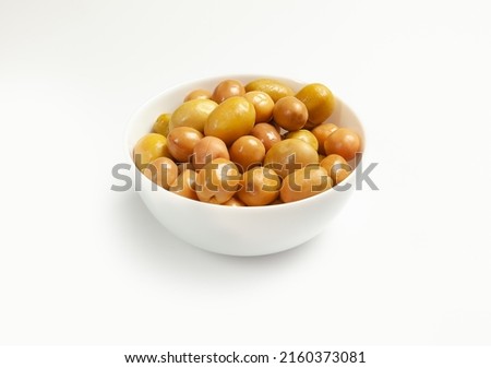 large green olives in a white bowl on a light background, side view