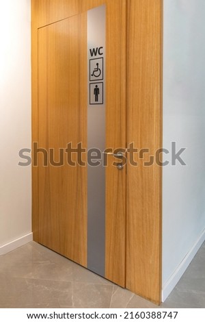 Public toilet for male and disabled visitor. Male and disabled person toilet sign on wooden door.