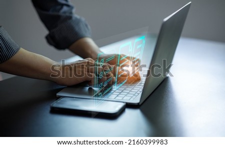 Business Hand using laptop computer with virtual screen and document for online approve paperless quality assurance and ERP management concept.